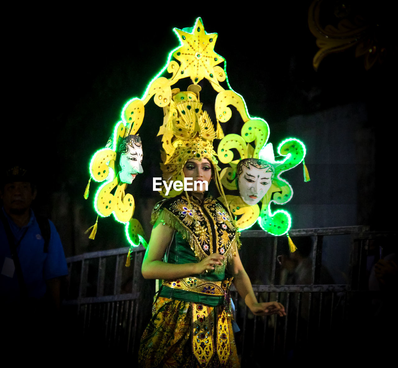 WOMAN STANDING BY ILLUMINATED LIGHTING EQUIPMENT