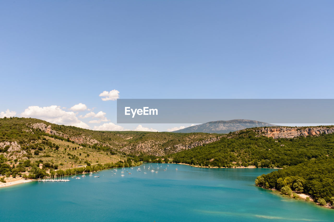 Scenic view of calm sea against mountain range