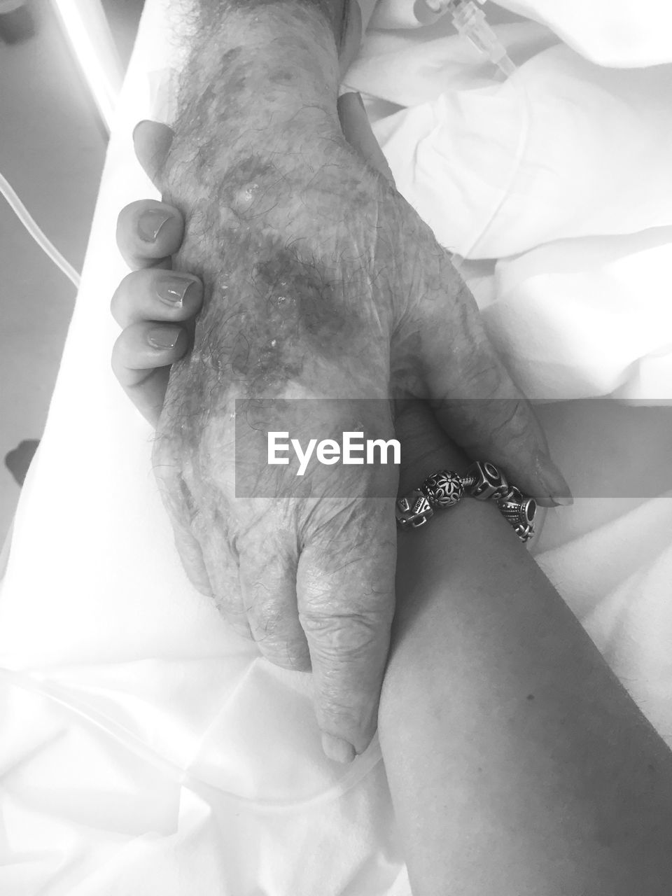 Cropped hand of woman holding patient in hospital