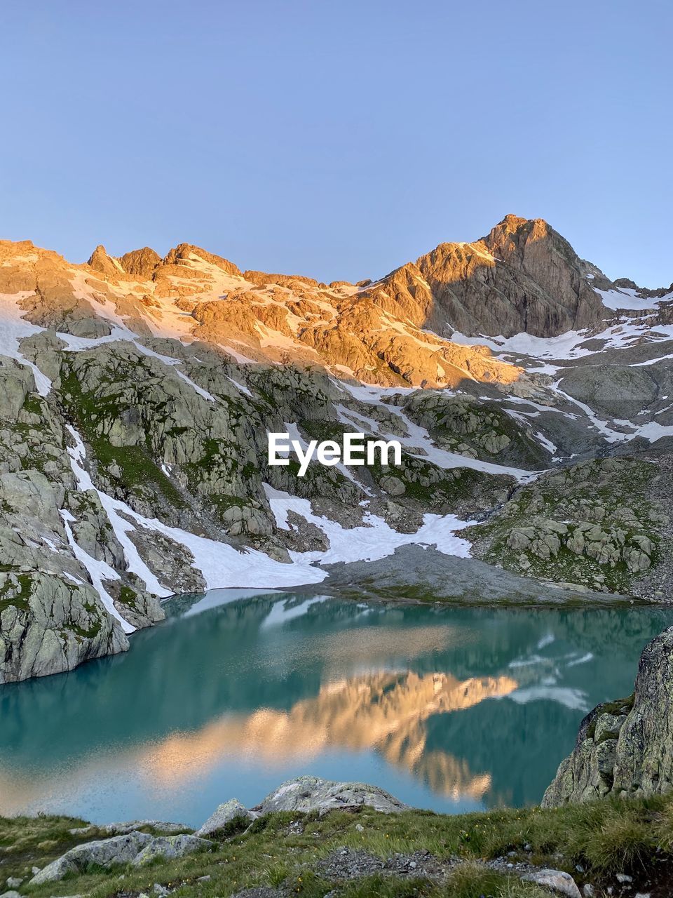 Scenic view of lake and mountains against clear sky