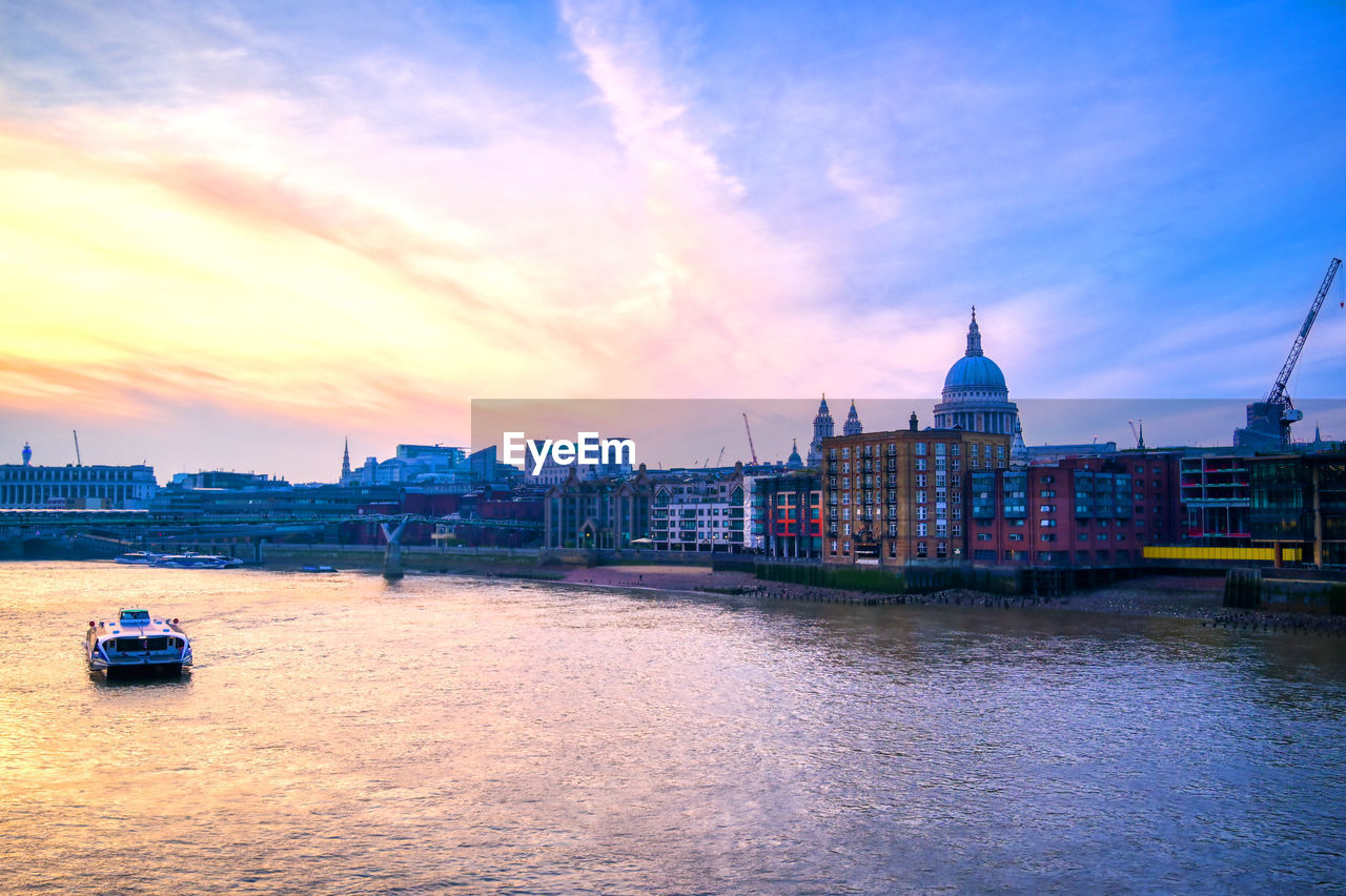 SCENIC VIEW OF RIVER BY BUILDINGS AGAINST SKY