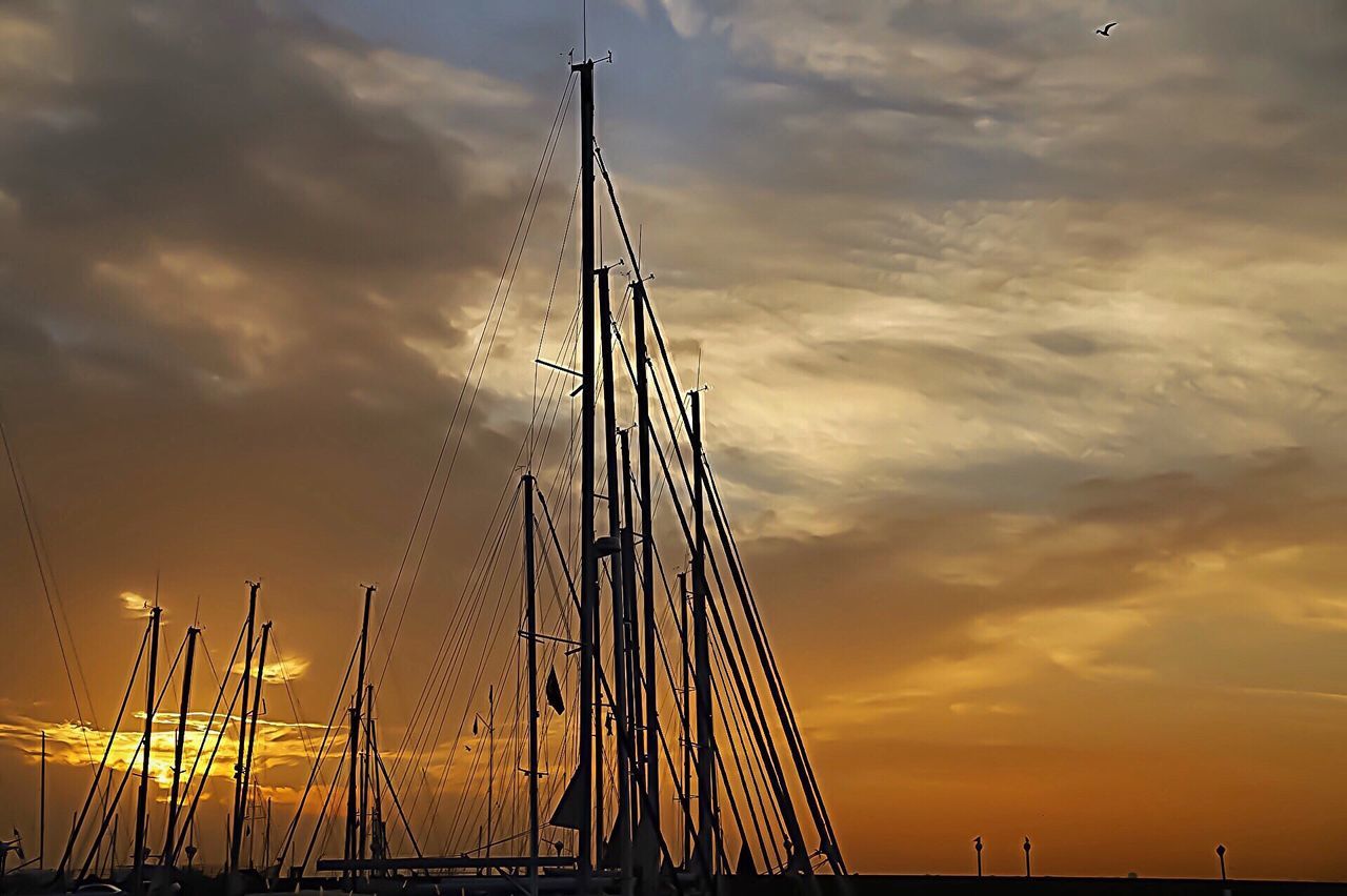 Low angle view of silhouette mast against orange sky