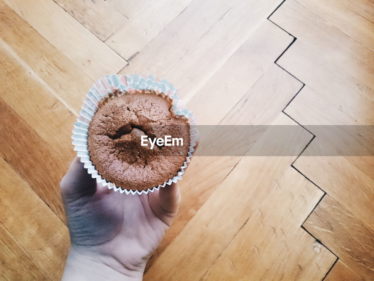 Cropped image hand holding cupcake