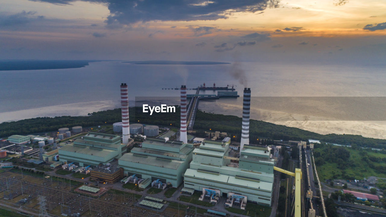 HIGH ANGLE VIEW OF INDUSTRY AGAINST SKY DURING SUNSET