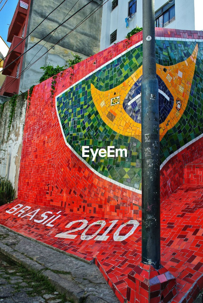 HIGH ANGLE VIEW OF TEXT ON STREET AGAINST BUILDING