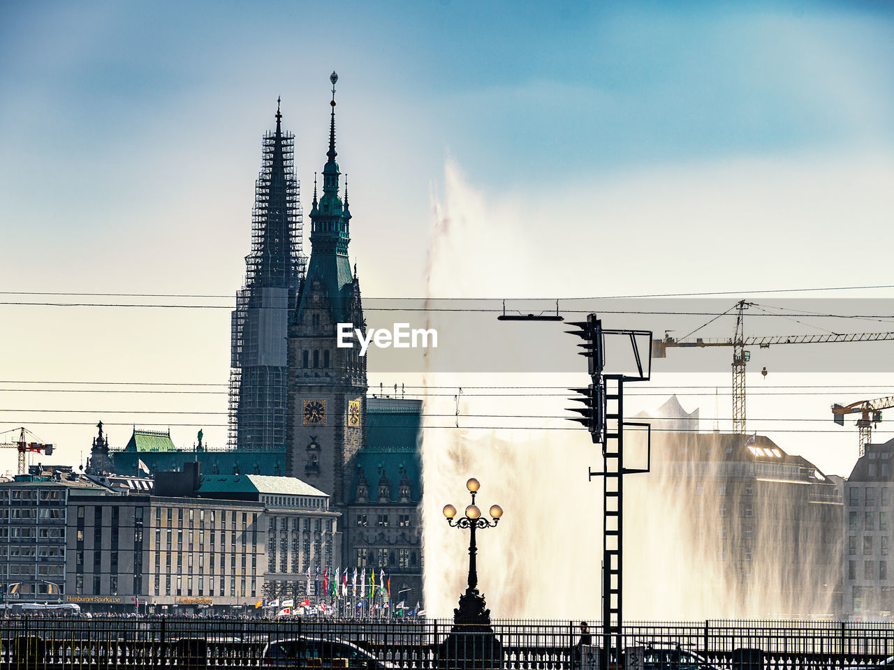 Low angle view of water fountain against hamburg rathaus