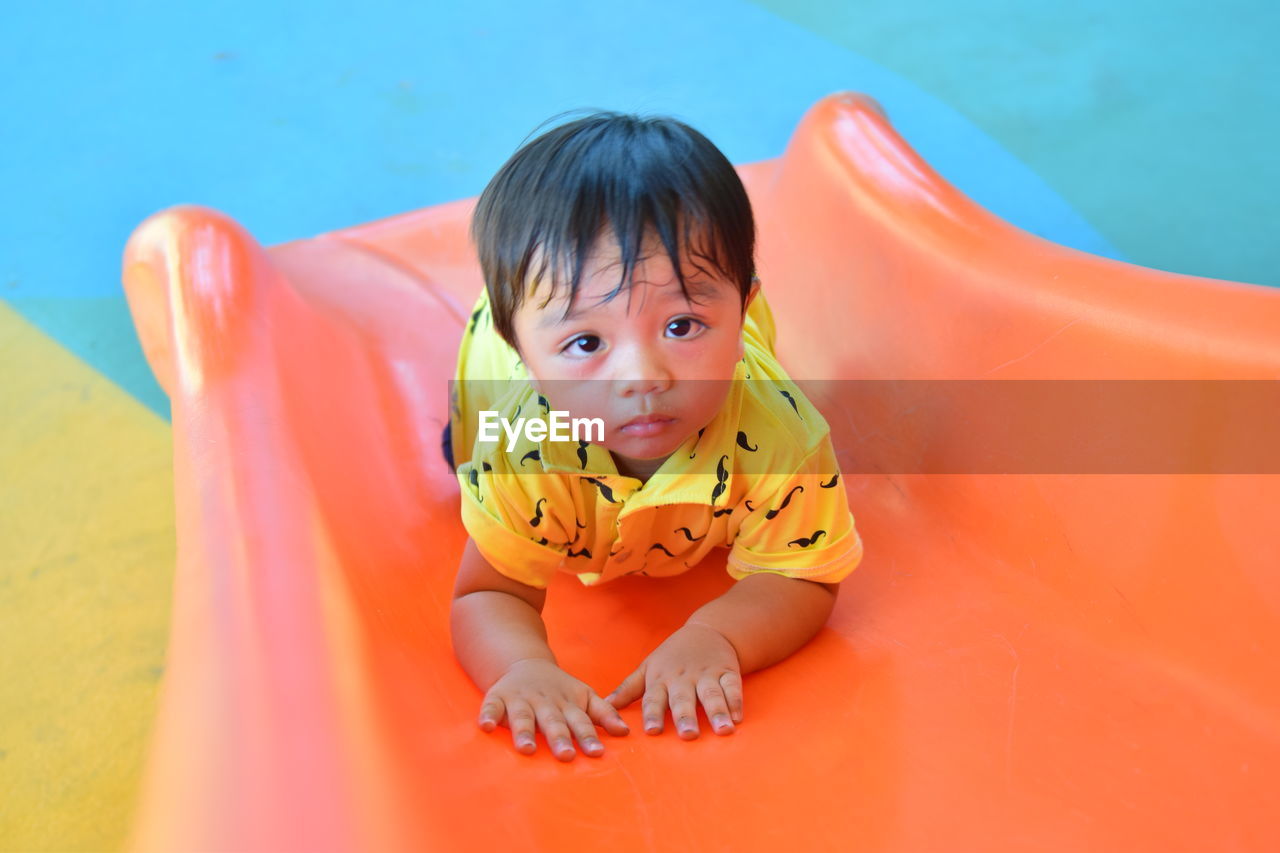 High angle portrait of cute boy on slide