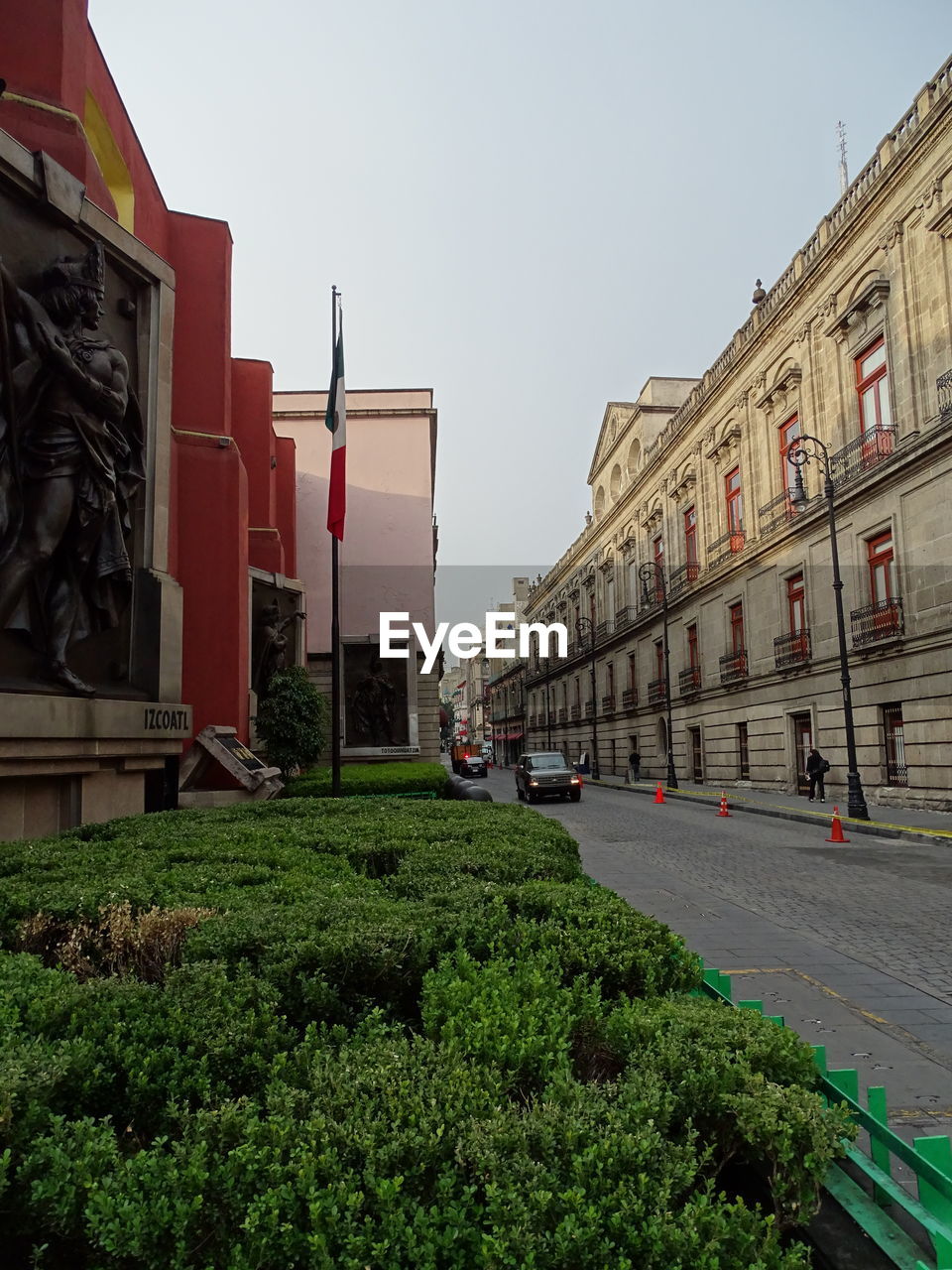 Sculpture on buildings in city against sky