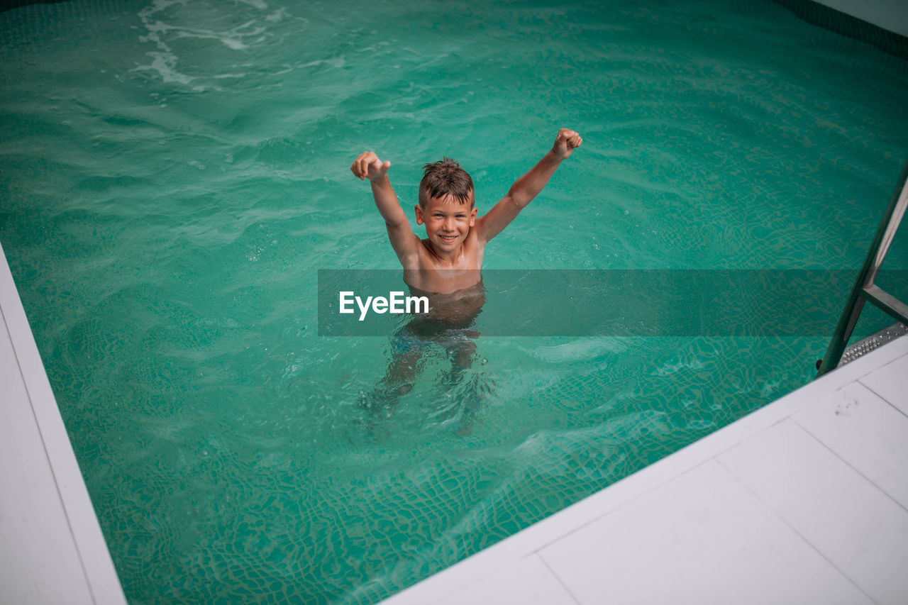 HIGH ANGLE VIEW OF MAN IN SWIMMING POOL