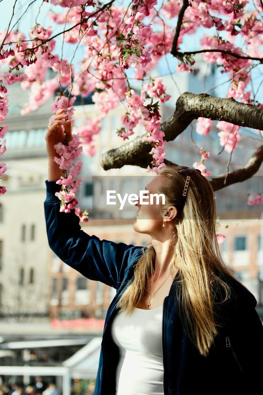 Woman looking at flowers on tree