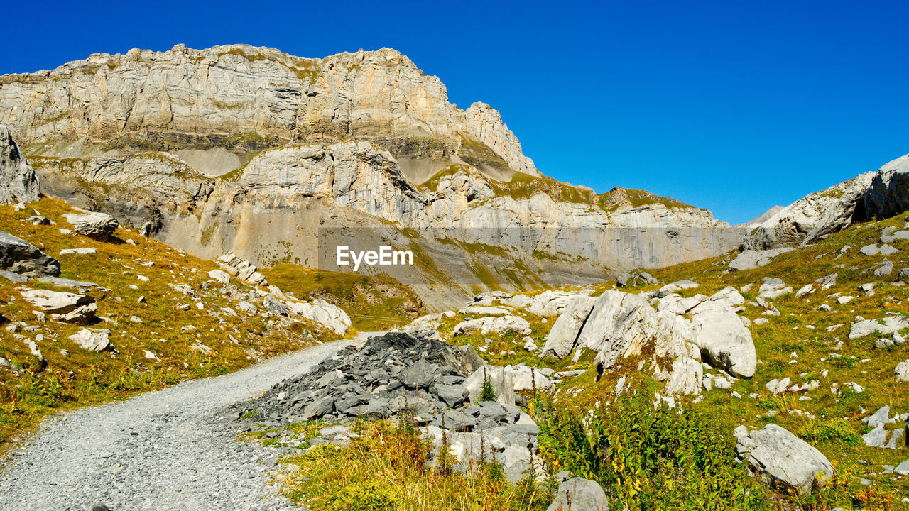 Low angle view of rocks against blue sky