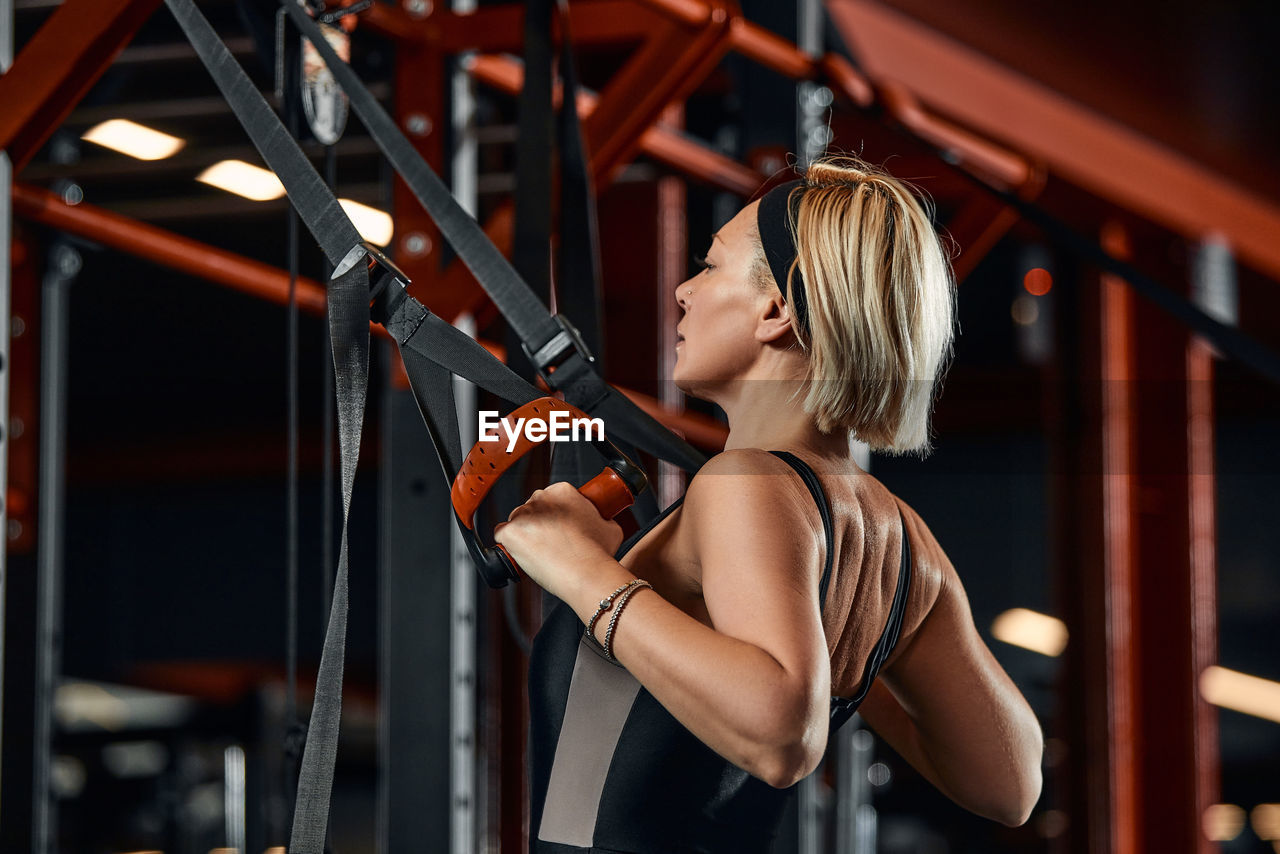 Rear view of woman exercising at gym