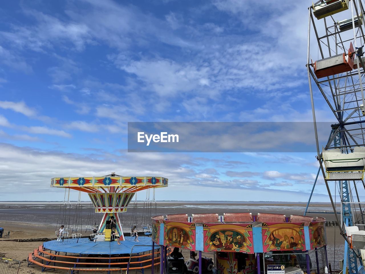 FERRIS WHEEL ON BEACH AGAINST SKY