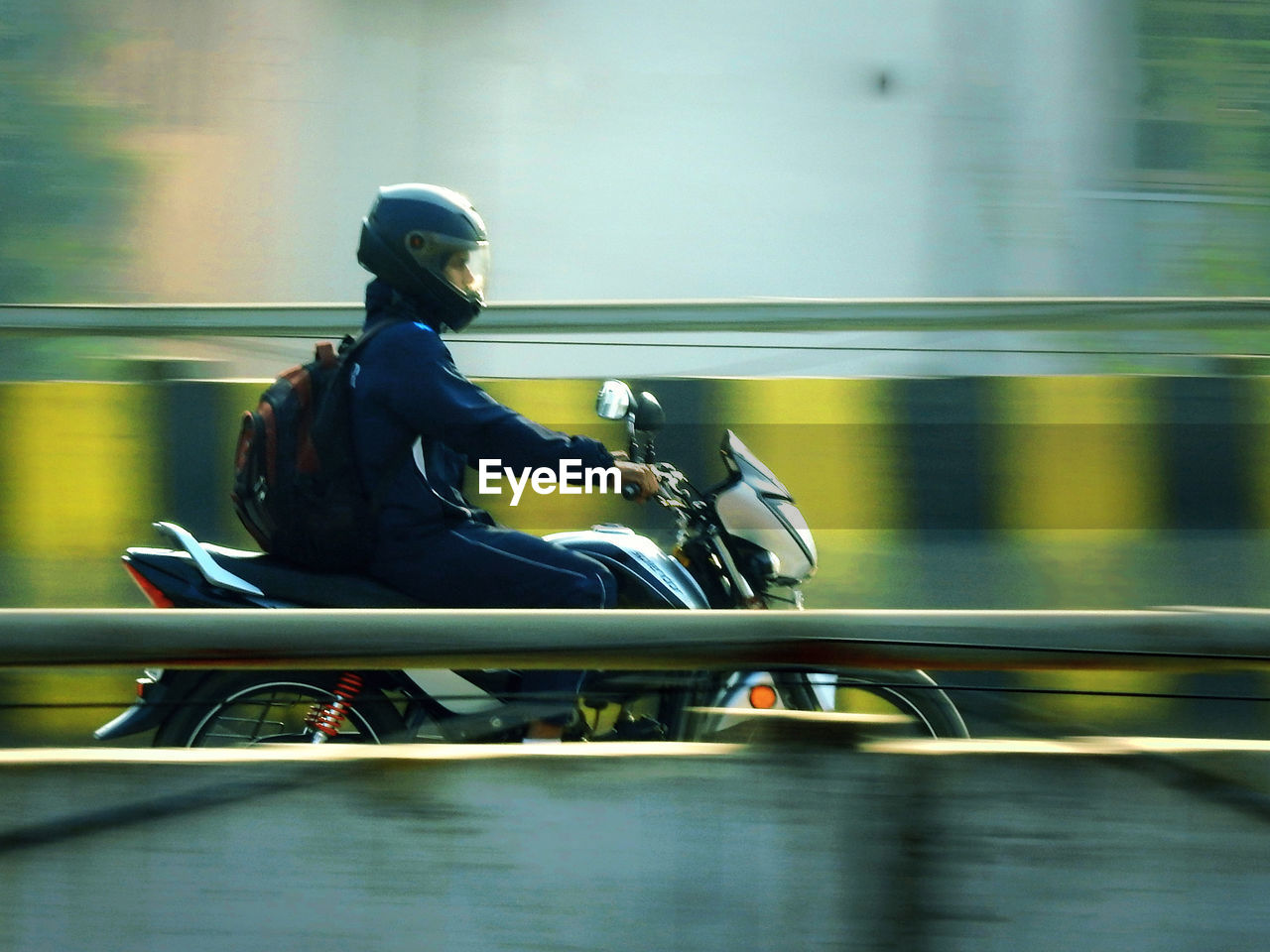 Side view of man riding motorcycle on bridge
