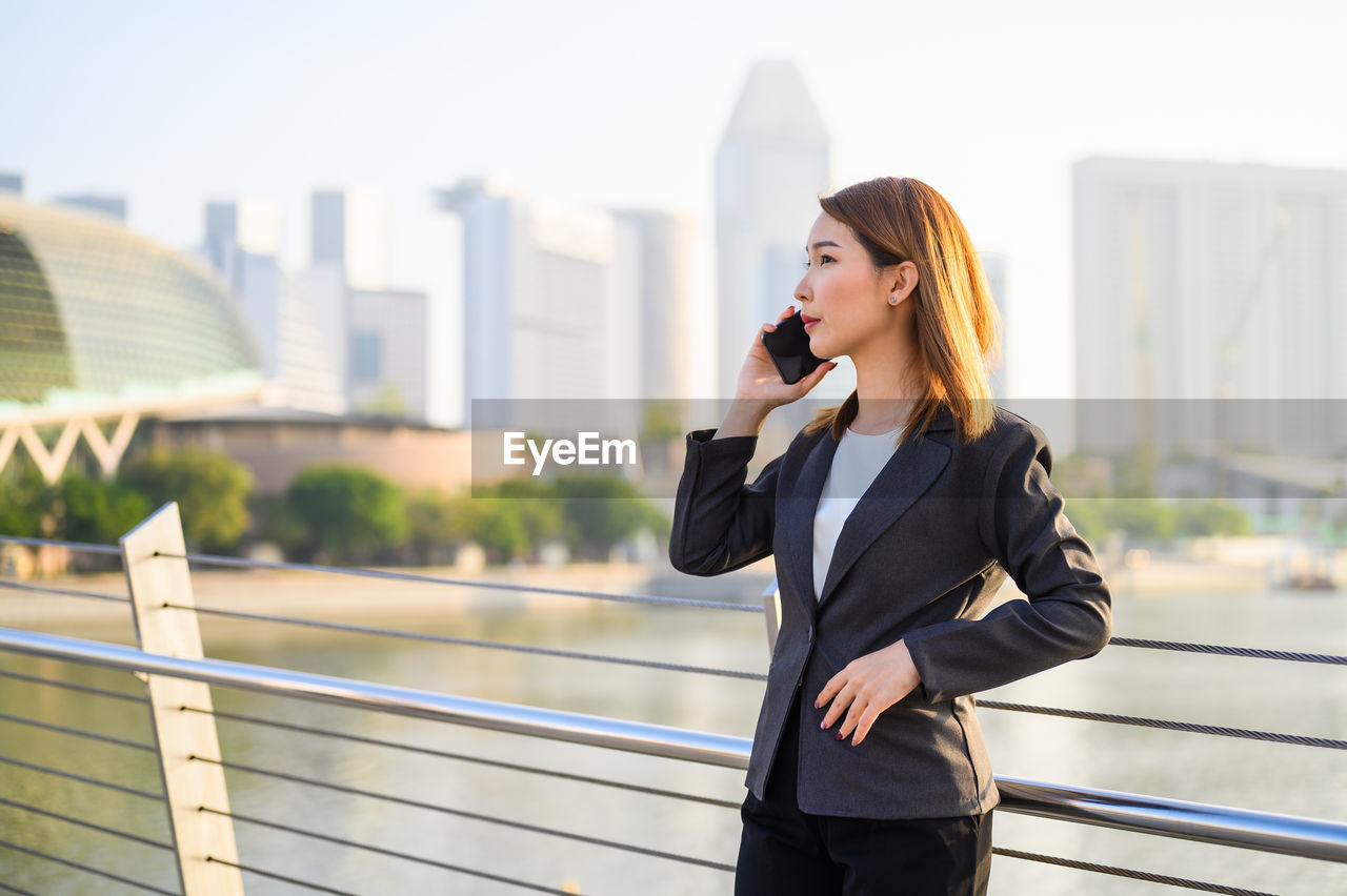 Businesswoman talking on phone while standing outdoors