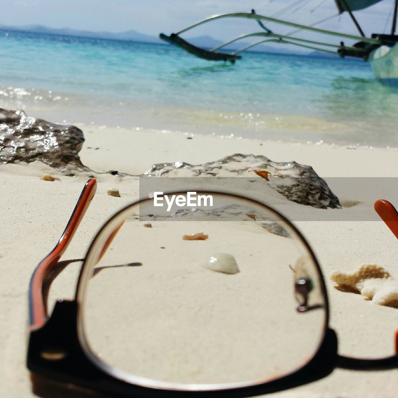 Close-up of eyeglasses on beach