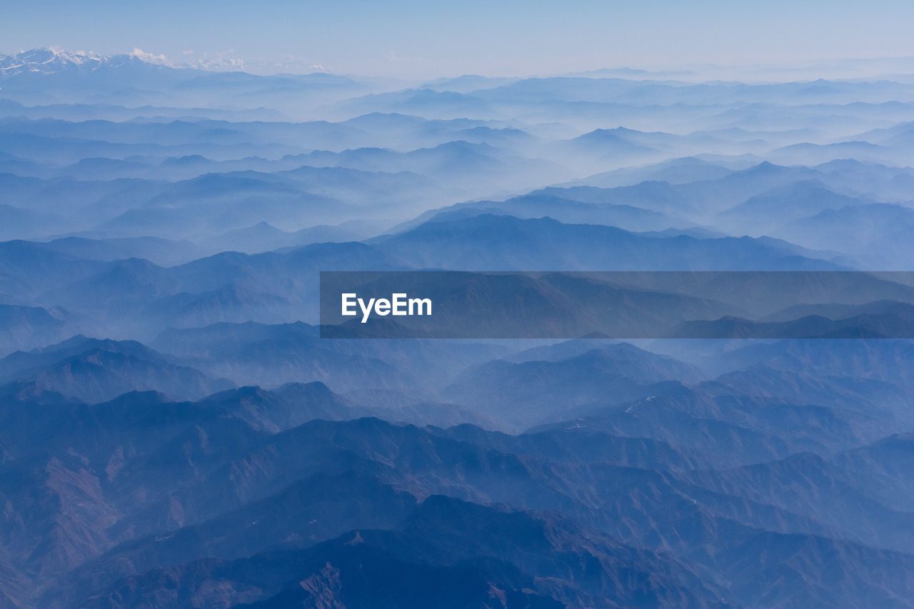 Scenic view of mountains against blue sky