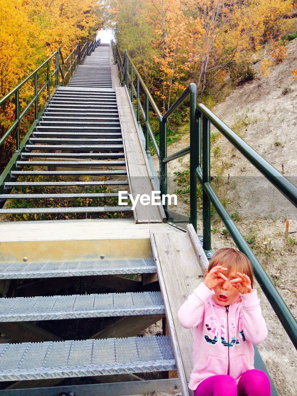 HIGH ANGLE VIEW OF WOMAN STANDING ON STAIRCASE