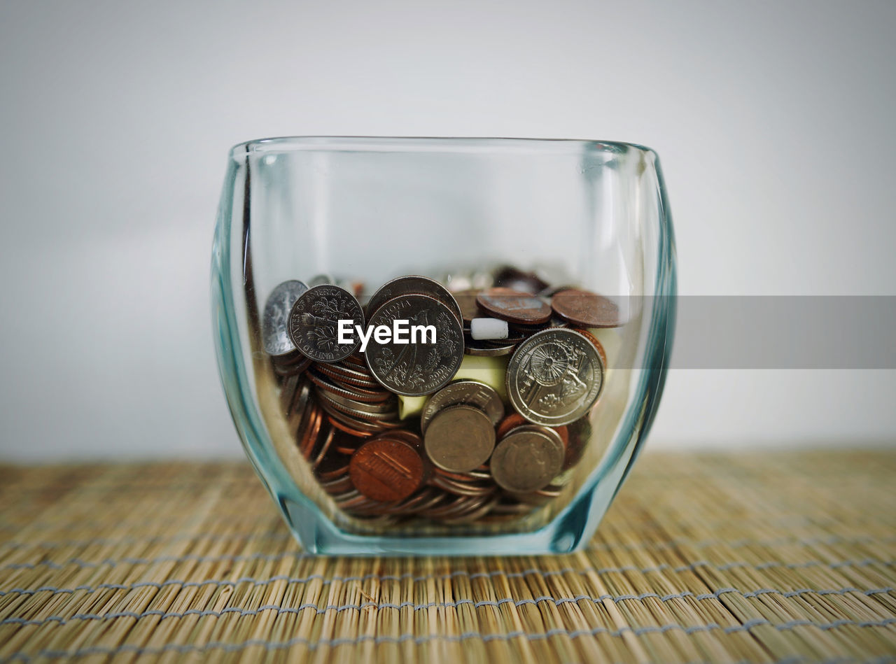 Close-up of coins in jar on table