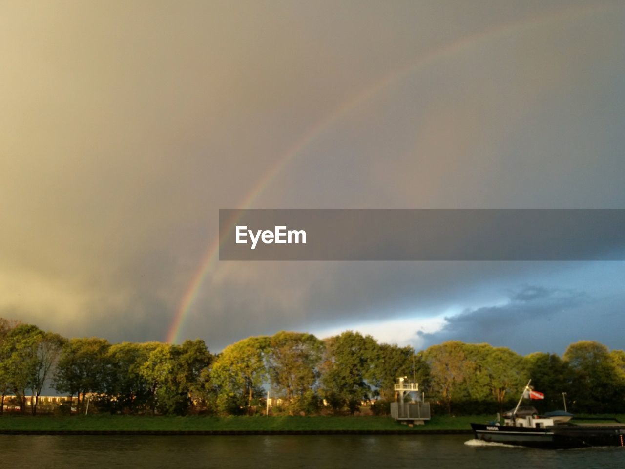 VIEW OF RAINBOW OVER LAKE AGAINST SKY