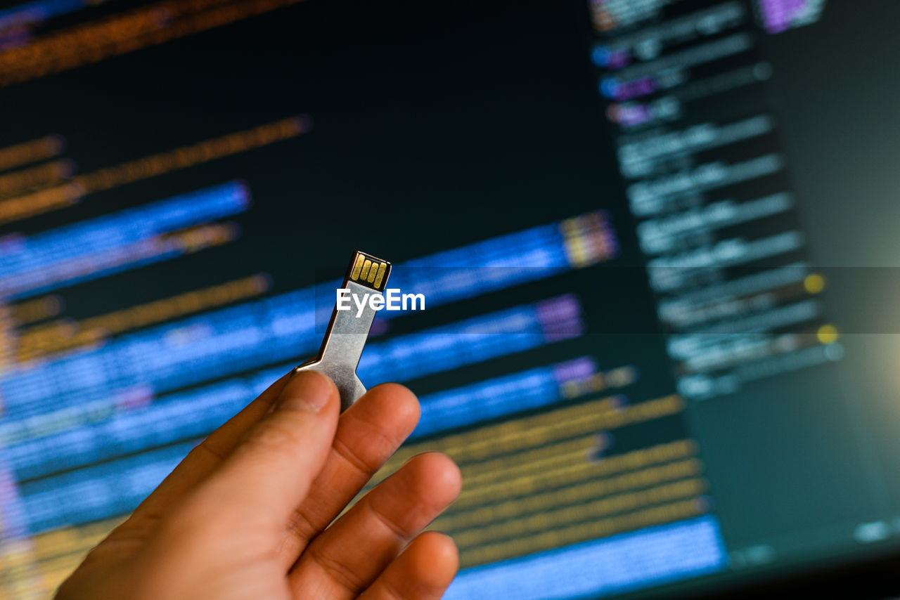 Cropped hand of person using usb stick