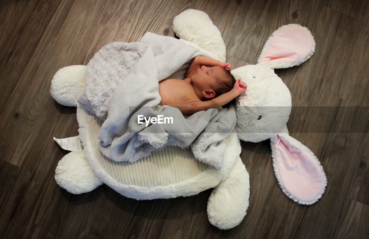 High angle view of cute baby sleeping on hardwood floor