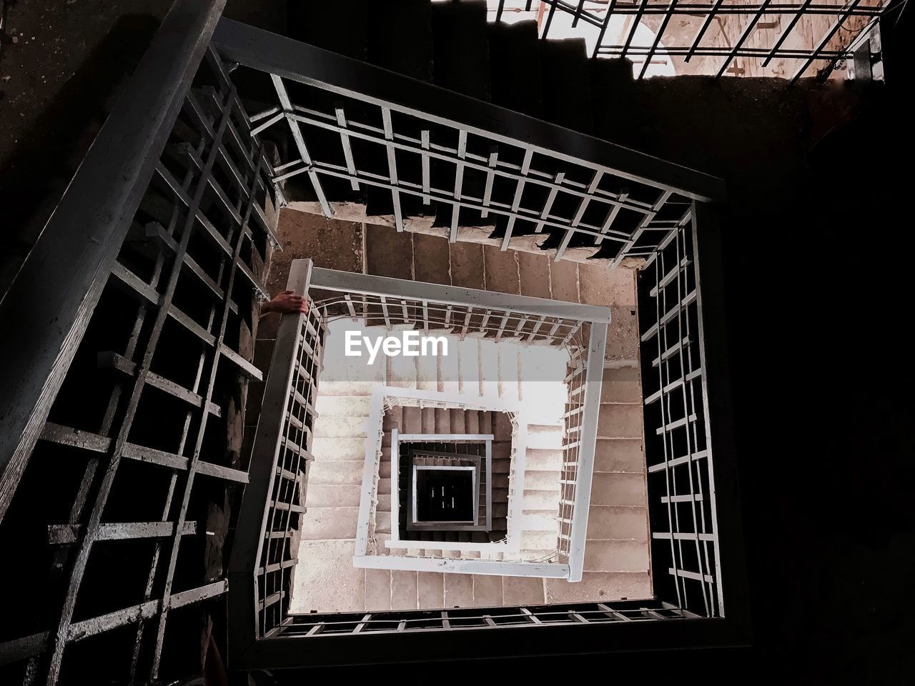 DIRECTLY BELOW VIEW OF SPIRAL STAIRCASE OF BUILDING