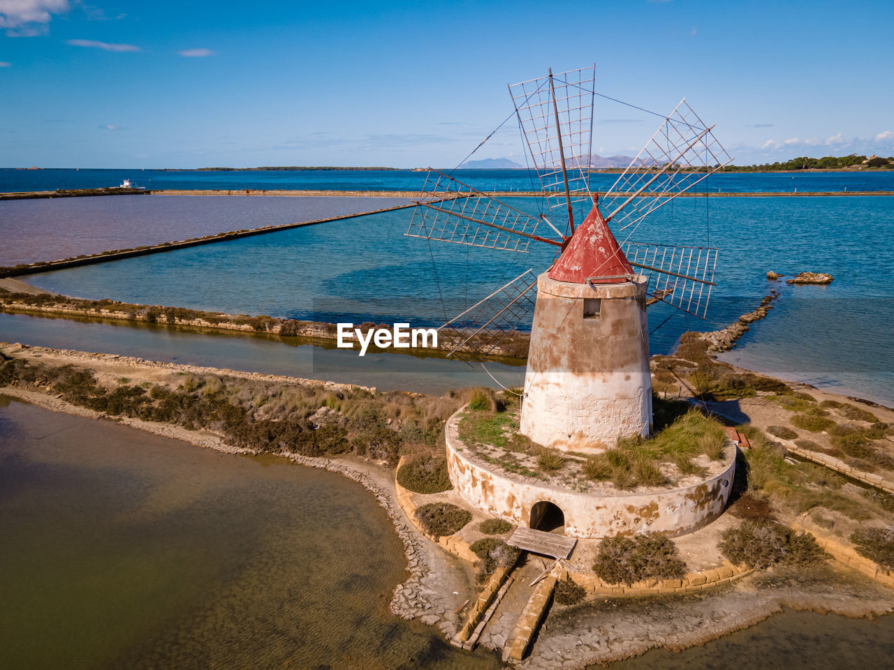 TRADITIONAL WINDMILL ON BEACH AGAINST SKY