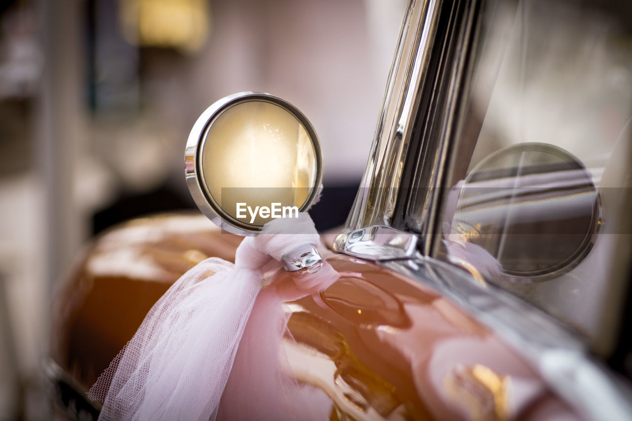 Close-up of fabric tied on side-view mirror of car