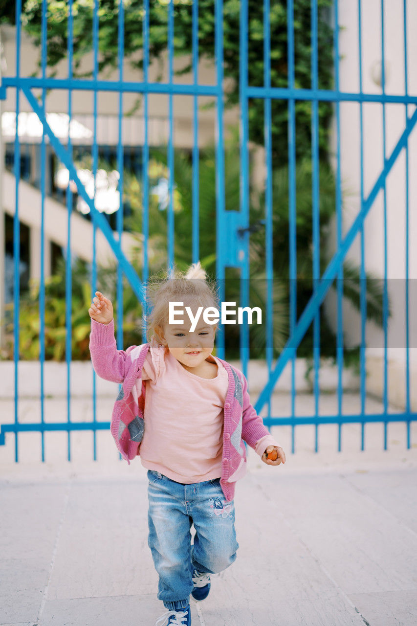 portrait of cute girl standing by railing