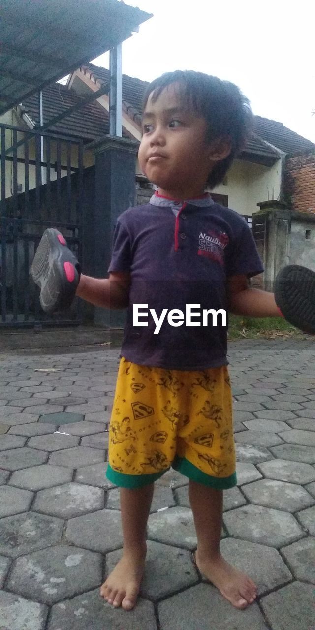 BOY STANDING ON FOOTPATH