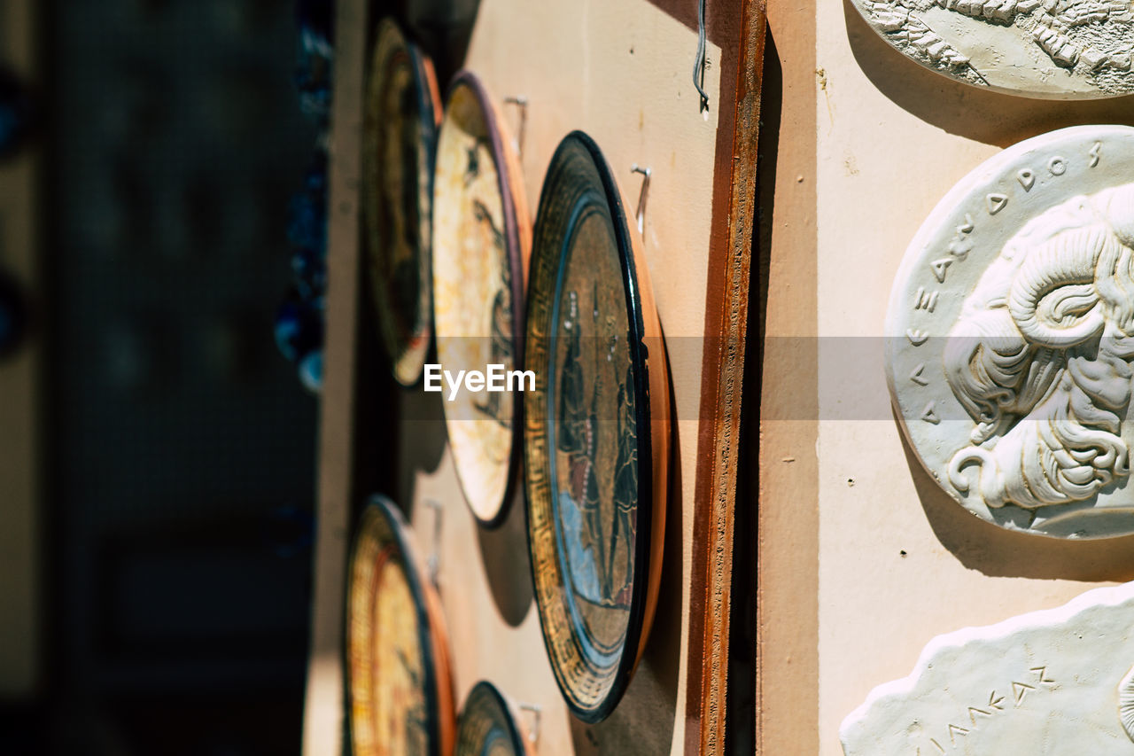 Close-up of old plates hanging on wall