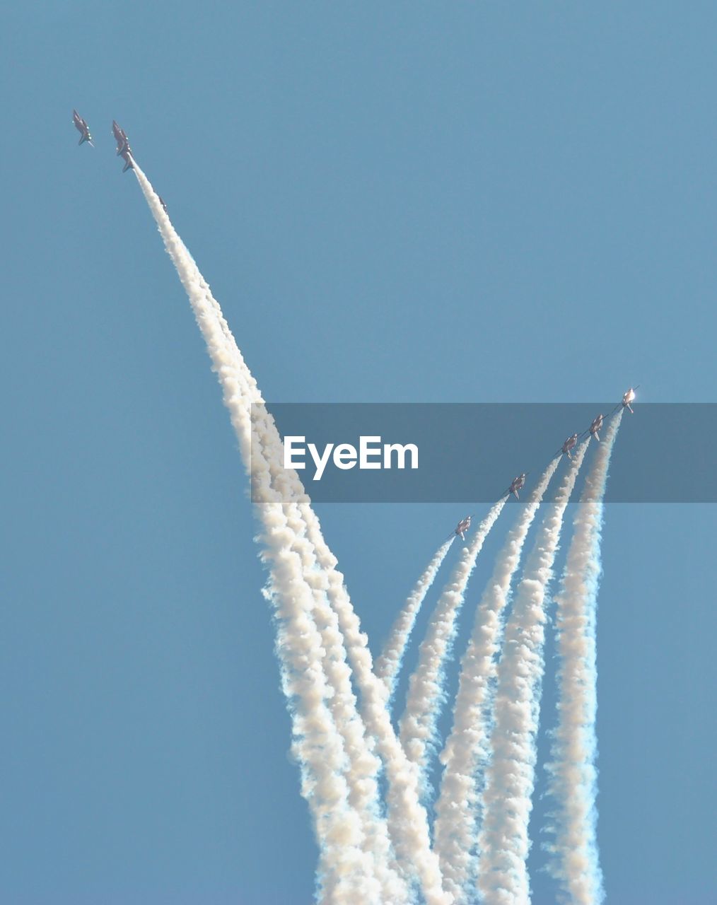 Low angle view of airshow flying against sky