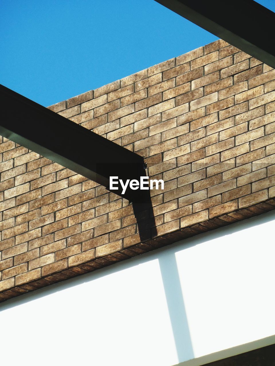 LOW ANGLE VIEW OF BRICK WALL AGAINST CLEAR SKY