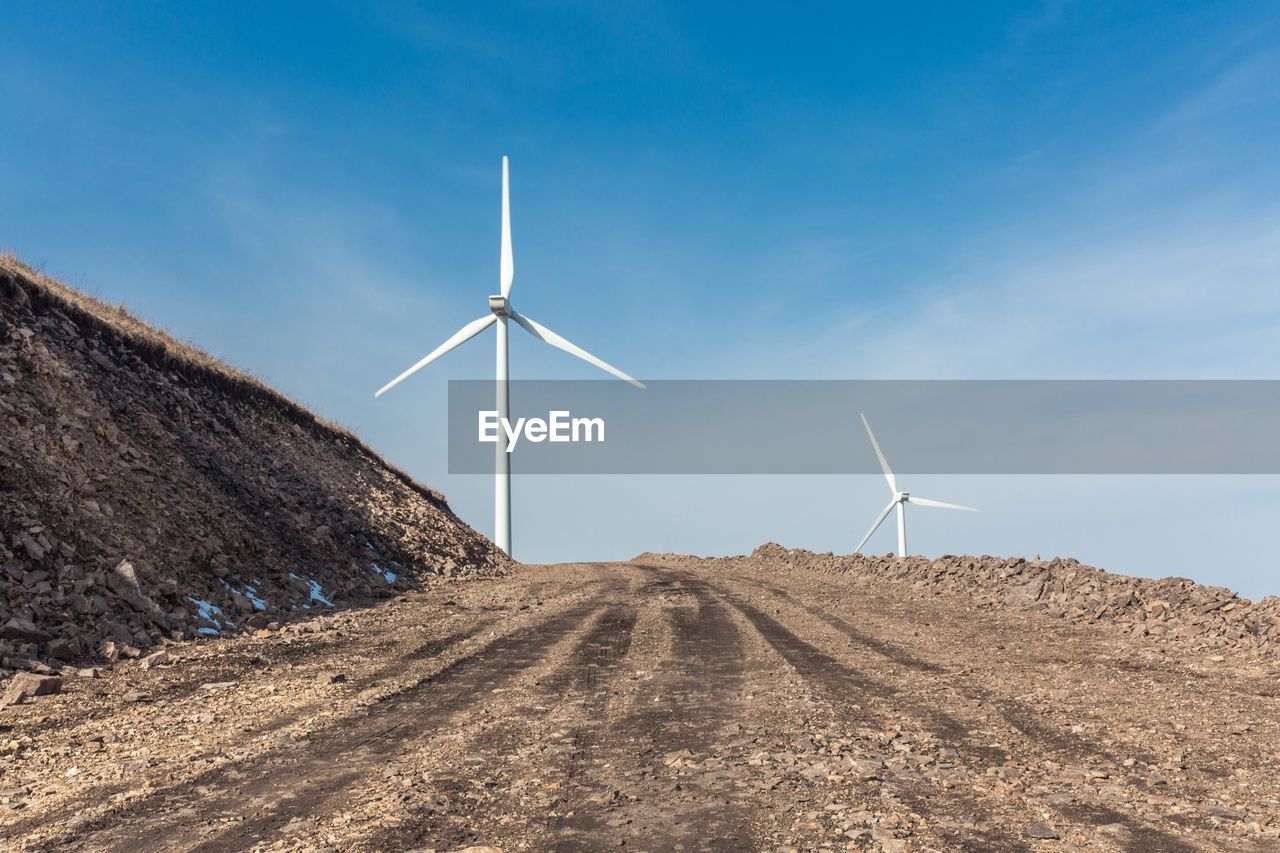 Close-up of windmill on field against blue sky