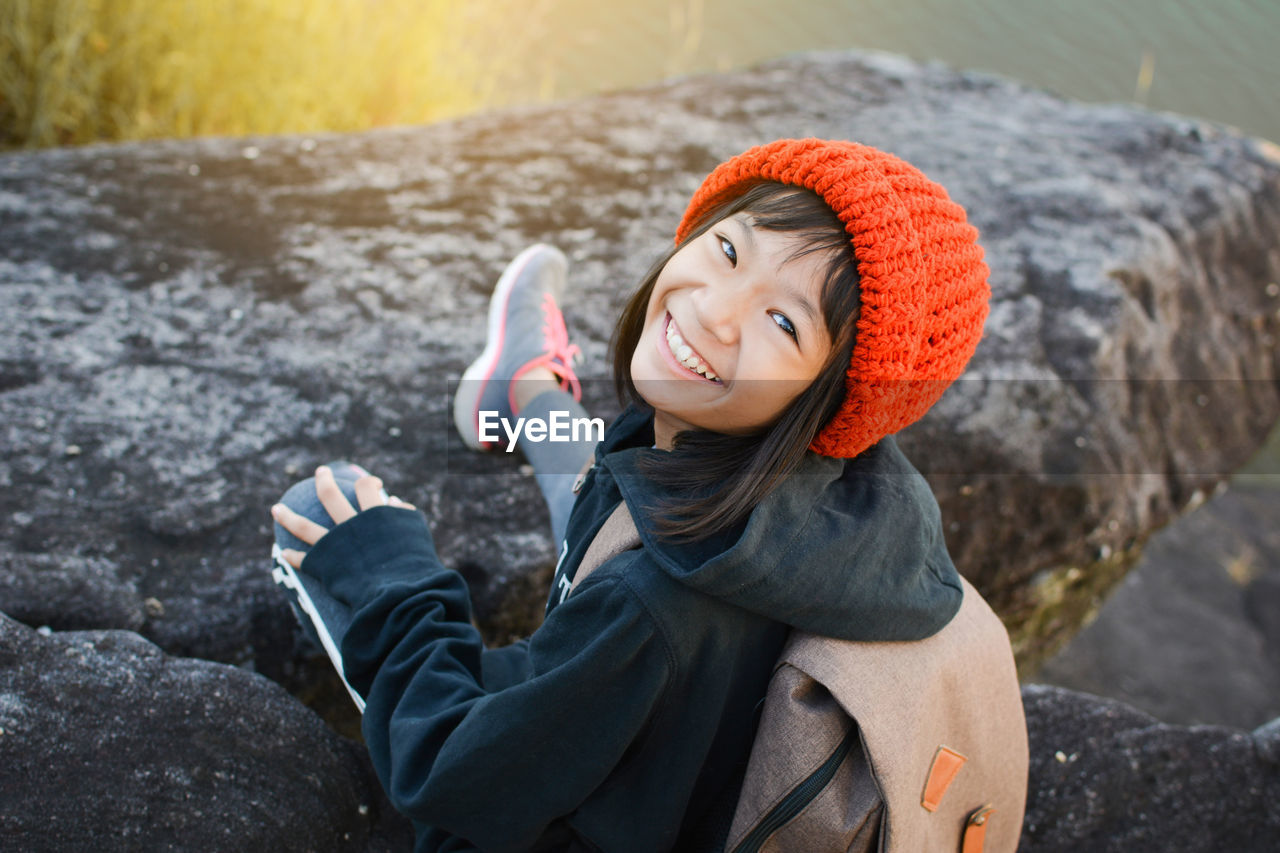 Portrait of girl sitting against lake