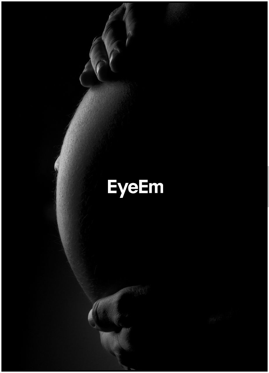 CLOSE-UP OF PERSON HAND HOLDING BLACK BACKGROUND