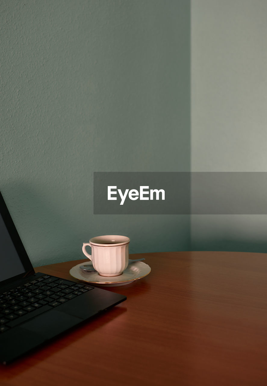 Coffee cup and a tablet on a corner table. conceptual image