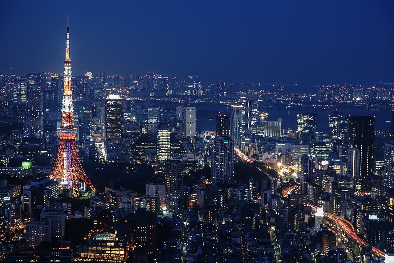 Illuminated cityscape against sky at night