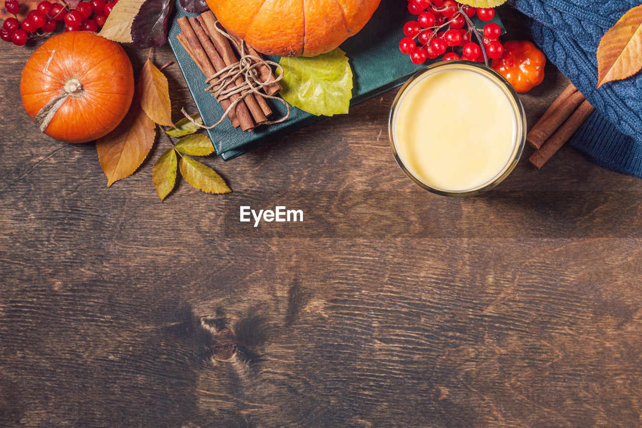 Autumn or winter vegan drink. healthy pumpkin smoothie in glasses on a wooden rustic table. 