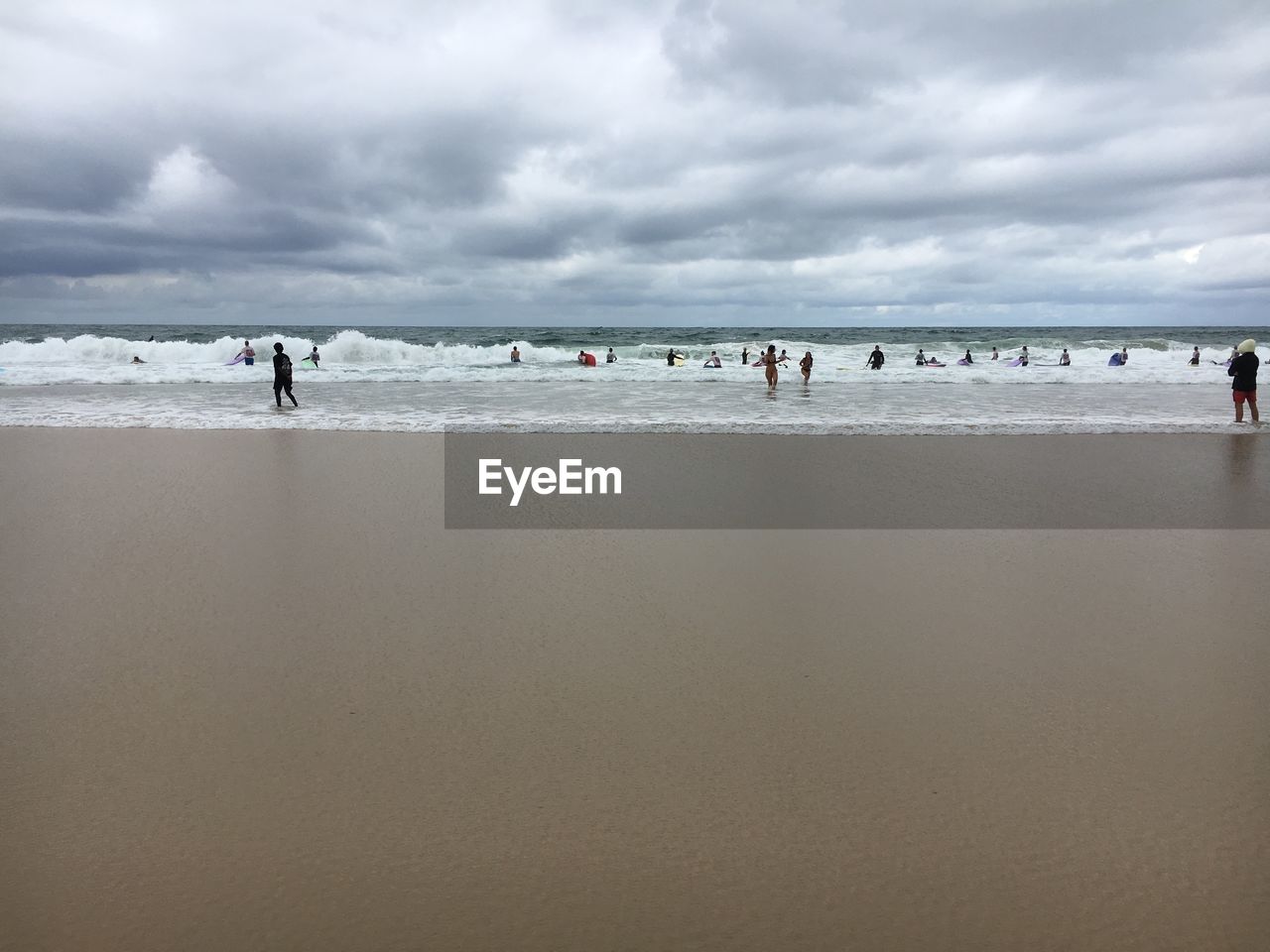 PEOPLE AT BEACH AGAINST SKY