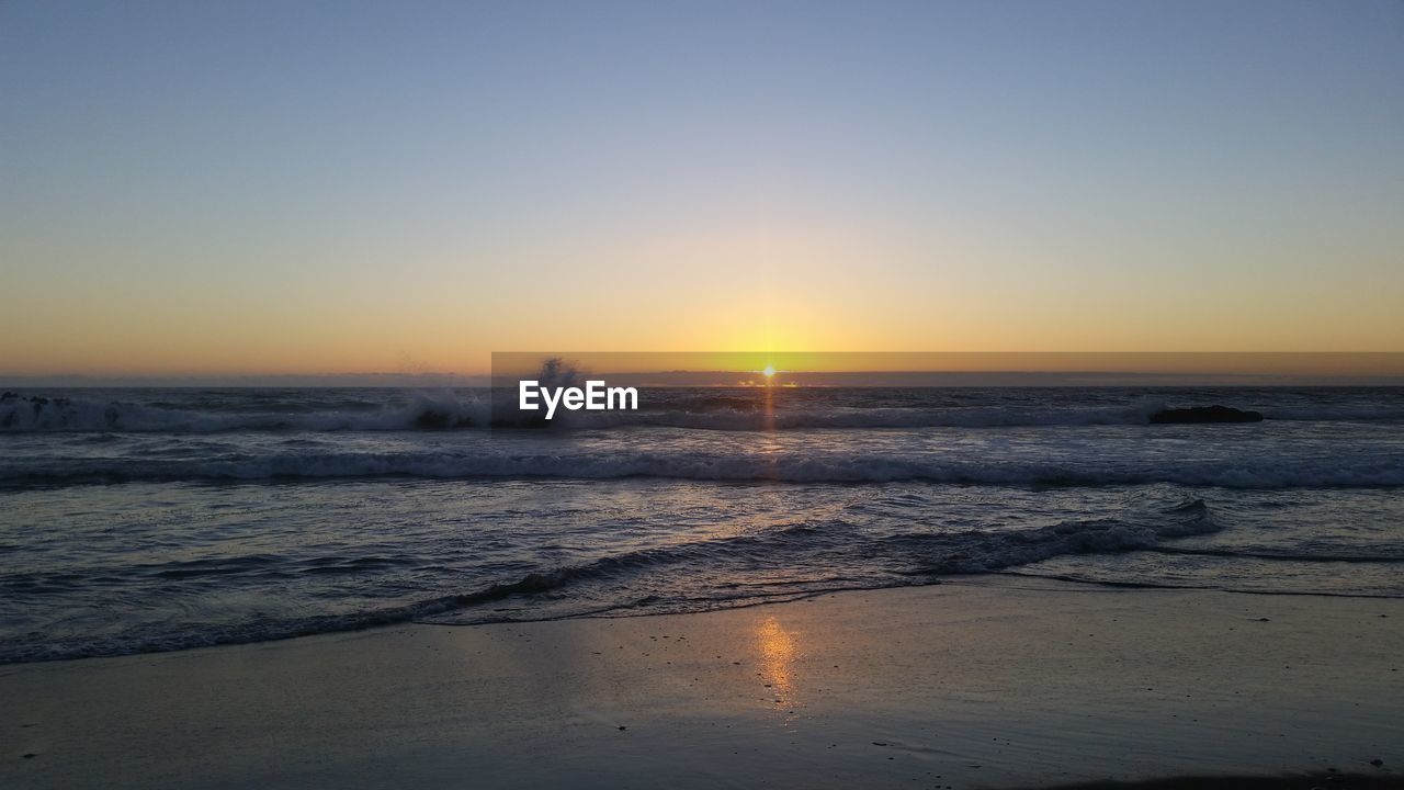 SCENIC VIEW OF SEA AGAINST CLEAR SKY AT SUNSET