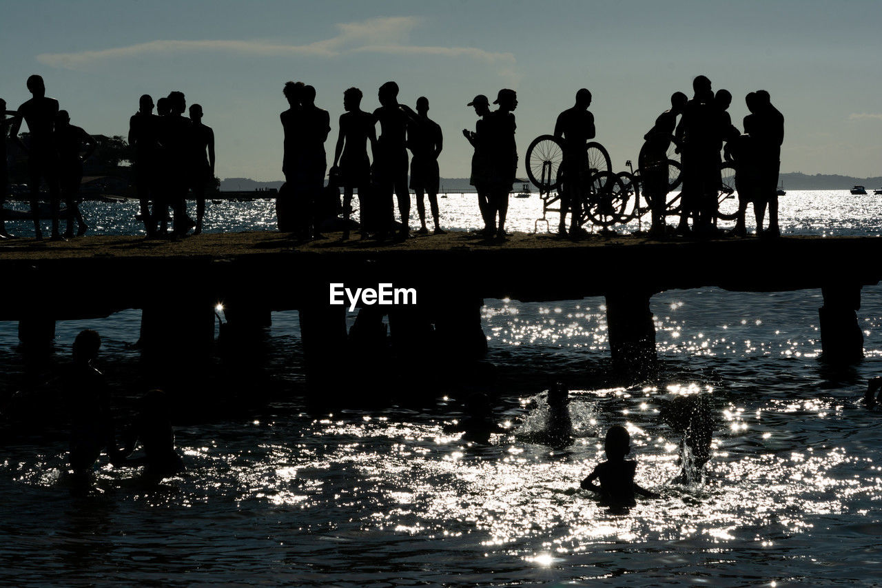 Young people, in silhouette, are seen having fun on the crush bridge in the late afternoon 