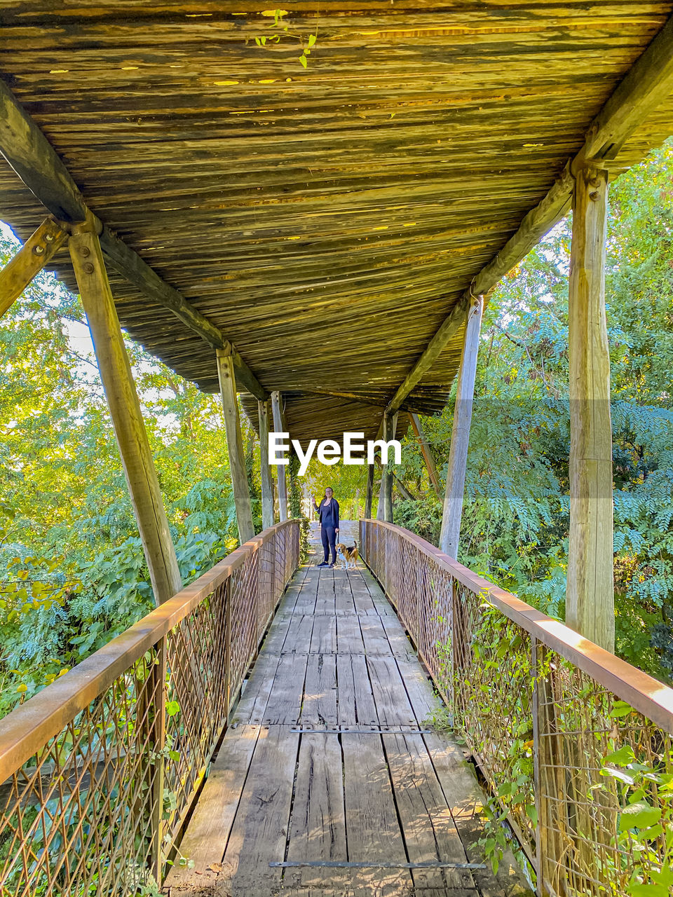 Rear view of man walking on footbridge