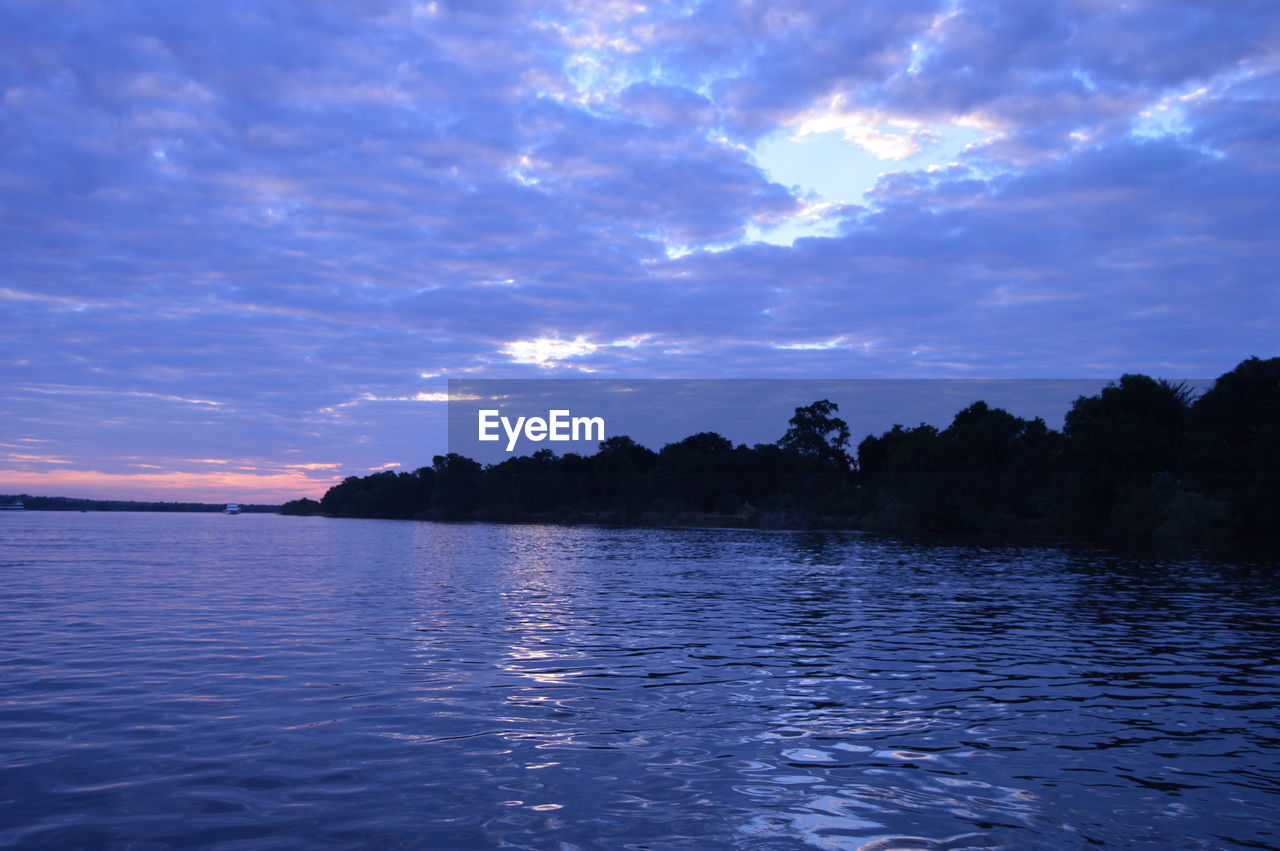 Scenic view of lake against sky at sunset