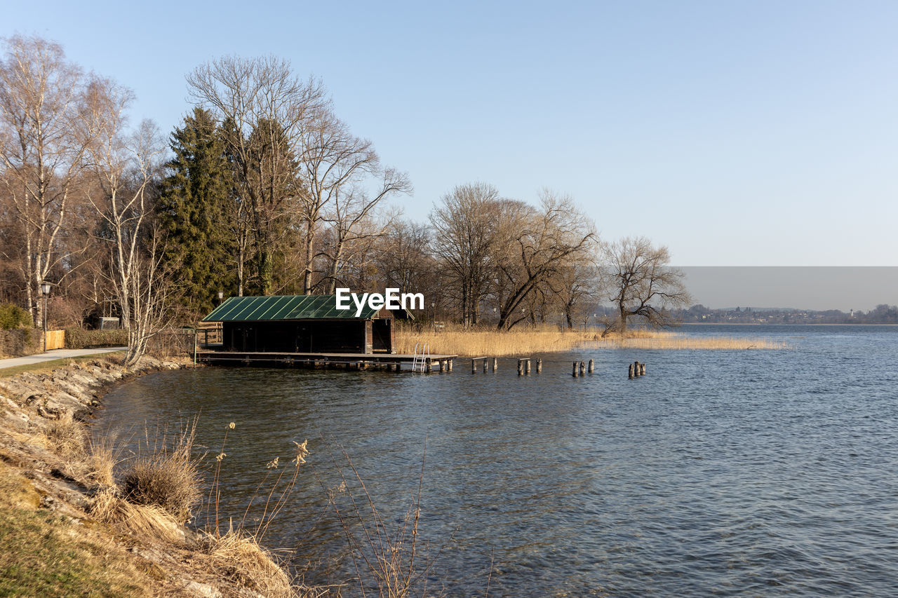 water, river, tree, sky, nature, architecture, built structure, plant, reservoir, no people, clear sky, waterway, day, reflection, shore, tranquility, building exterior, scenics - nature, bare tree, house, landscape, body of water, beauty in nature, building, outdoors, environment, tranquil scene, sunny, non-urban scene, blue, rural scene, rural area
