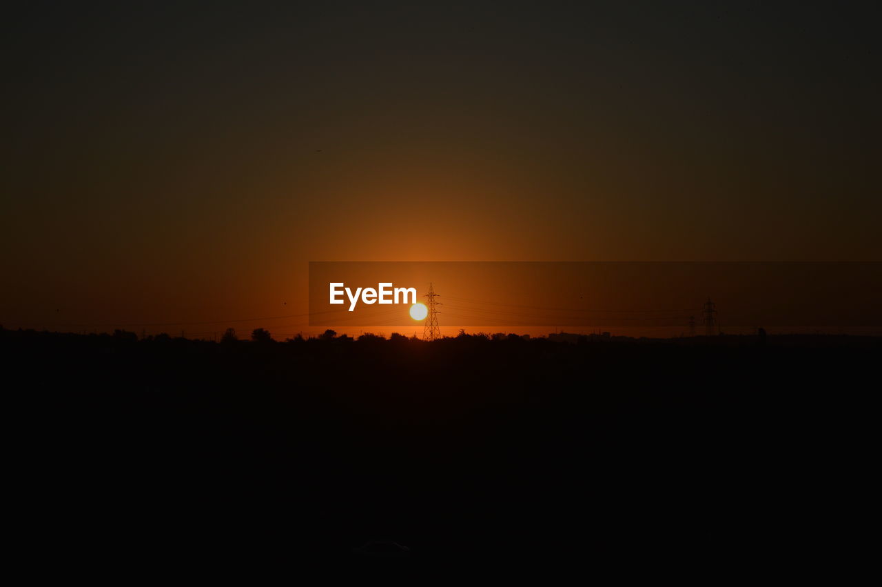 SCENIC VIEW OF SILHOUETTE FIELD AGAINST SKY DURING SUNSET