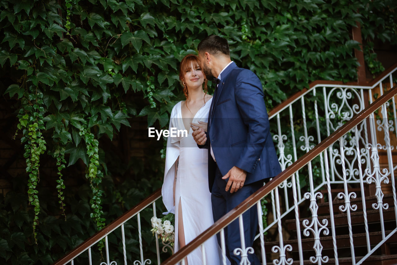 railing, adult, women, wedding dress, two people, men, ceremony, emotion, bride, positive emotion, love, togetherness, happiness, architecture, formal wear, standing, smiling, staircase, wedding, female, young adult, lifestyles, event, married, celebration, nature, bridge, day, clothing, outdoors, newlywed