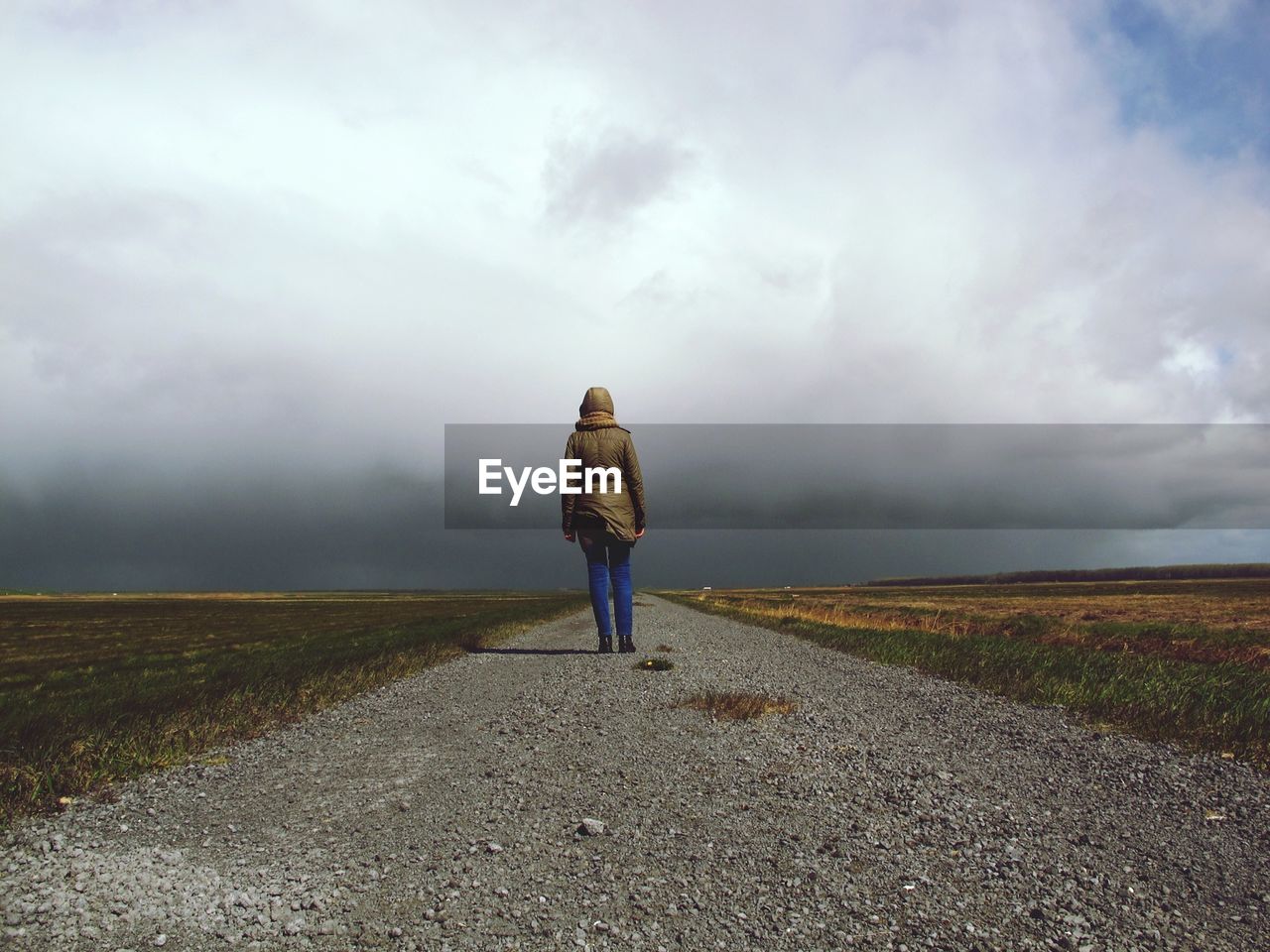 Rear view of woman on road against sky