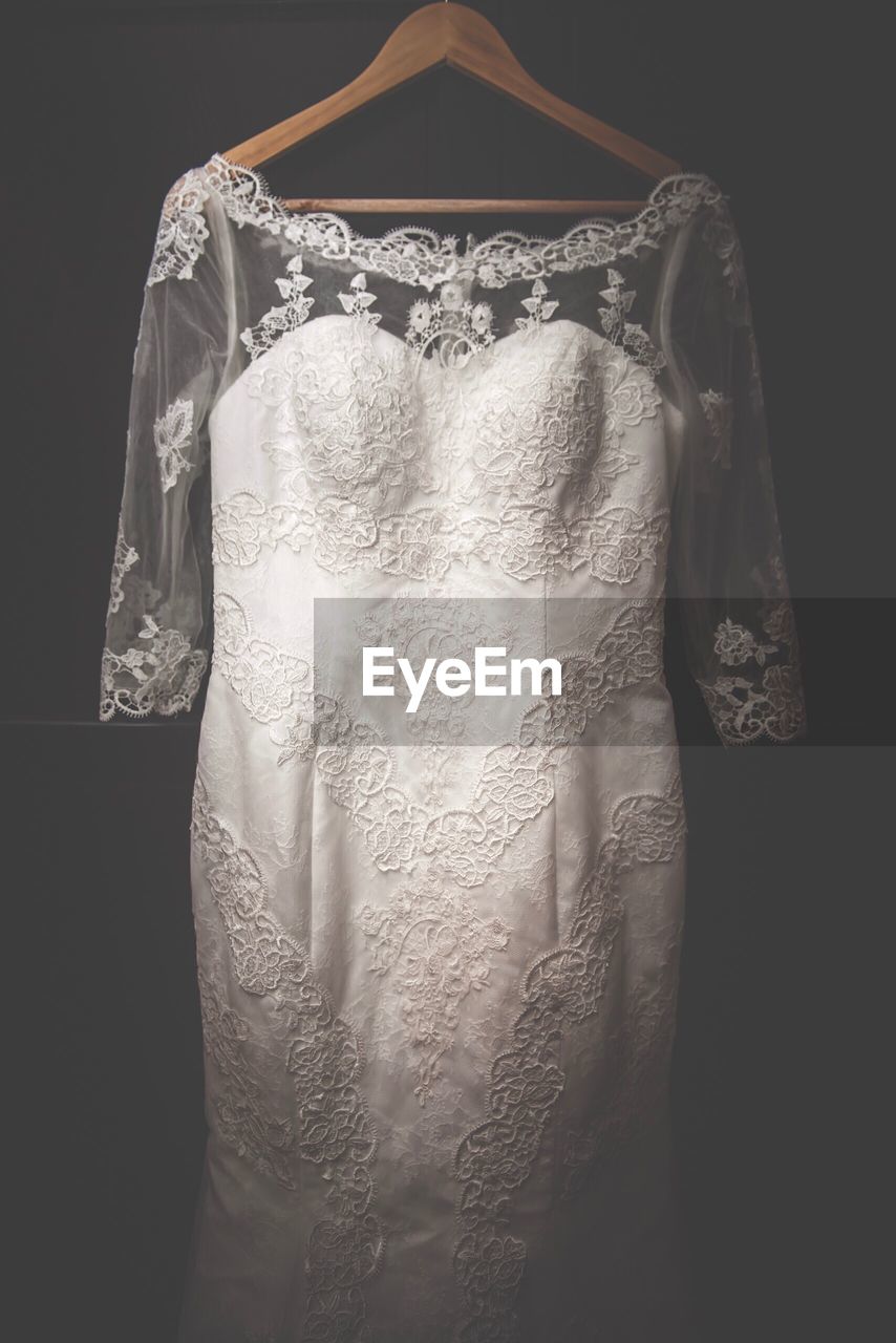 Close-up of wedding dress against black background